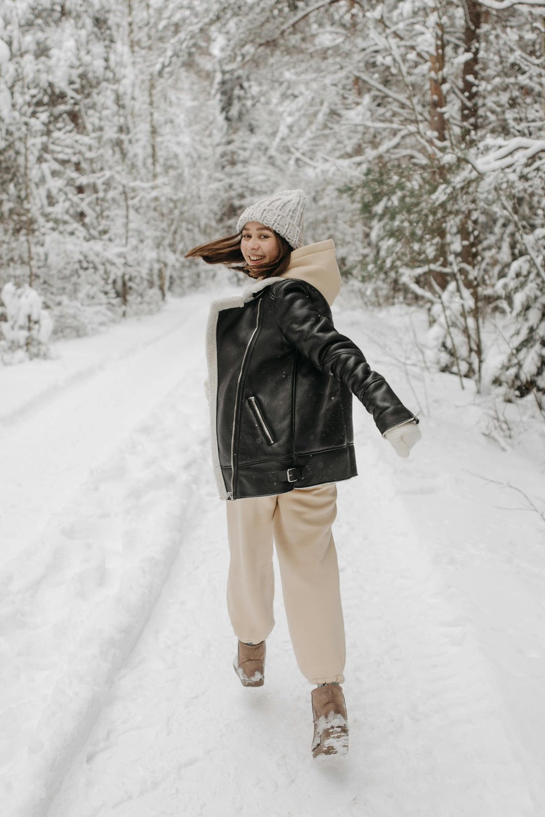 Women Walking In Snow Wearing A Leather Jacket And Hoodie